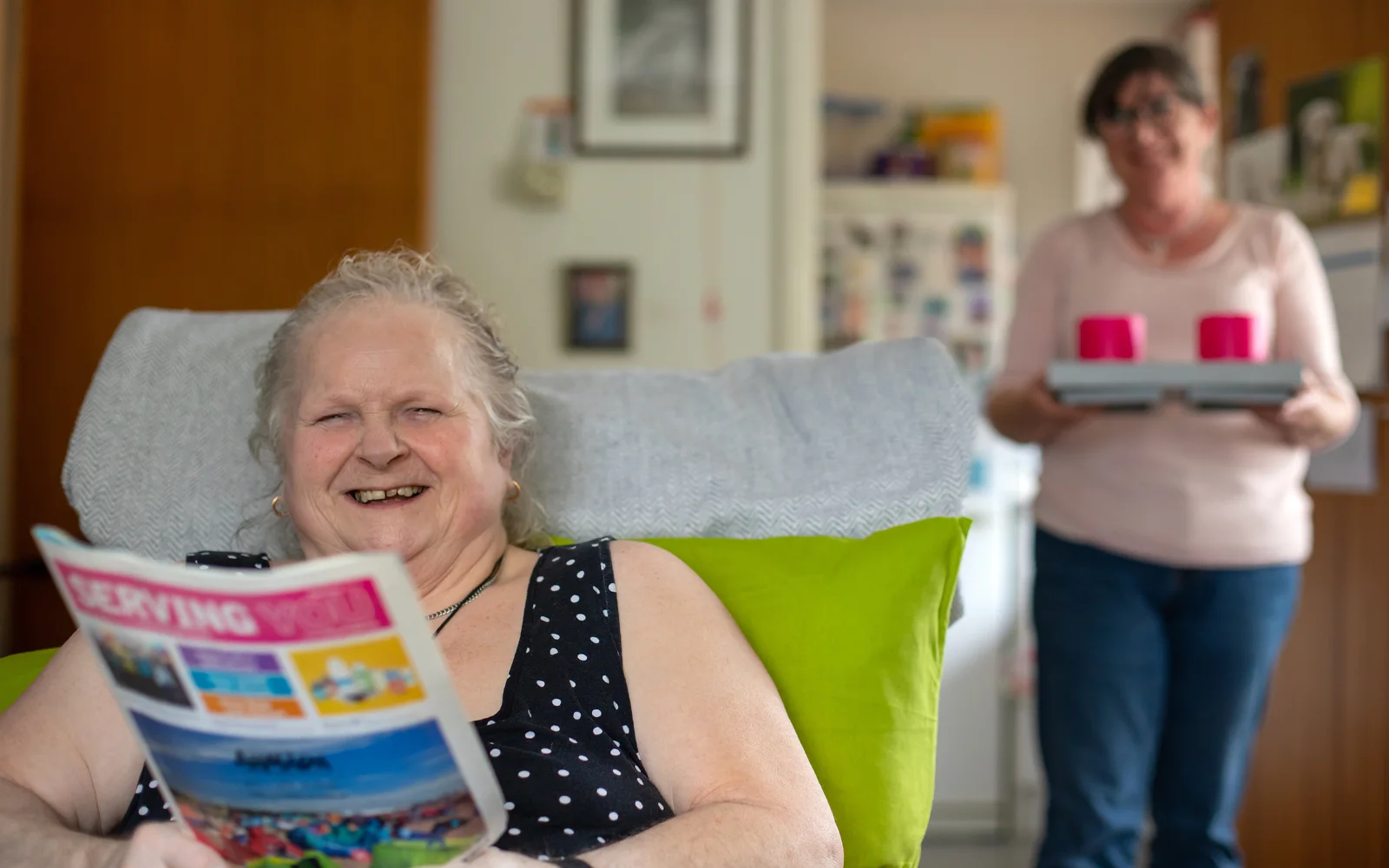 Client reading and carer holding tray